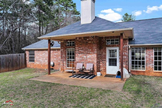 back of house with a lawn and a patio