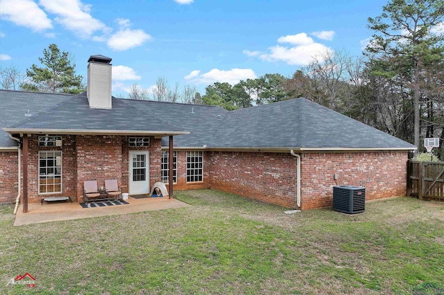 rear view of property featuring a lawn, a patio, and central air condition unit