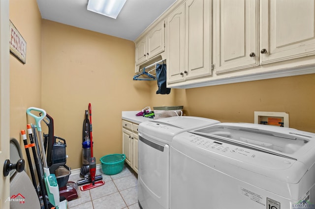 laundry room featuring cabinets, washing machine and dryer, and light tile patterned floors