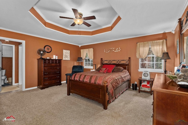 carpeted bedroom with crown molding, ceiling fan, a tray ceiling, and multiple windows