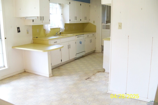 kitchen with white cabinetry, a sink, light countertops, dishwasher, and light floors