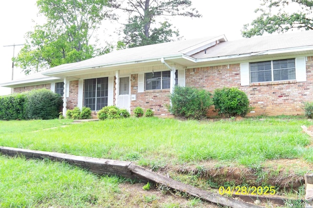 single story home with brick siding and a front yard