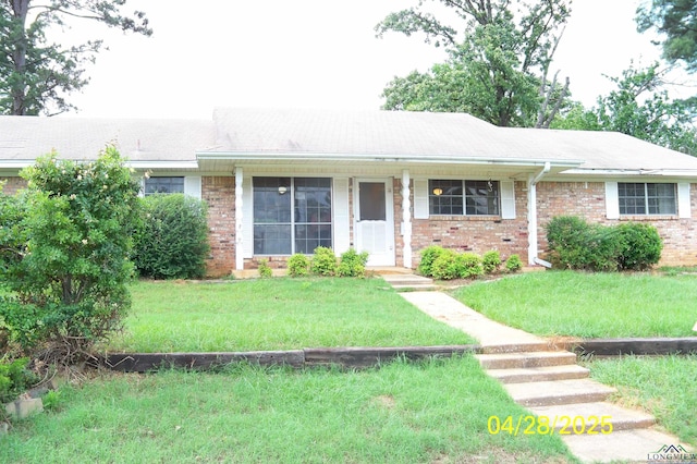ranch-style house with brick siding and a front lawn