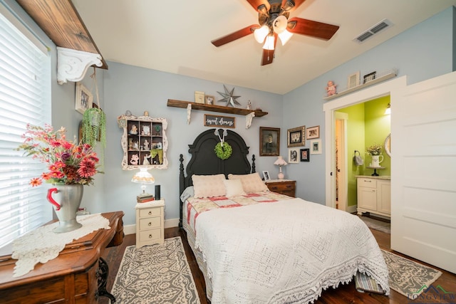 bedroom featuring ceiling fan, dark wood-type flooring, and ensuite bath