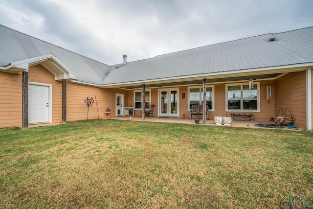 back of house with french doors and a lawn