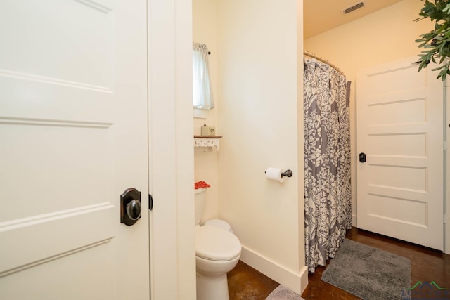 bathroom featuring a shower with curtain and toilet