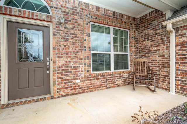 property entrance featuring brick siding