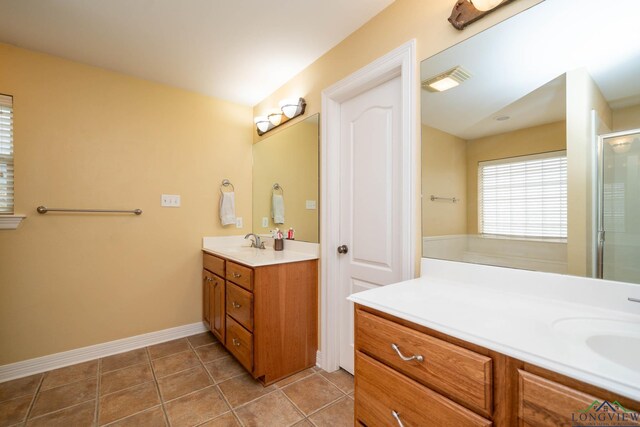 bathroom featuring visible vents, baseboards, vanity, tile patterned floors, and a shower with door