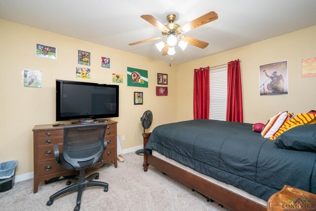 bedroom with light carpet, ceiling fan, and baseboards