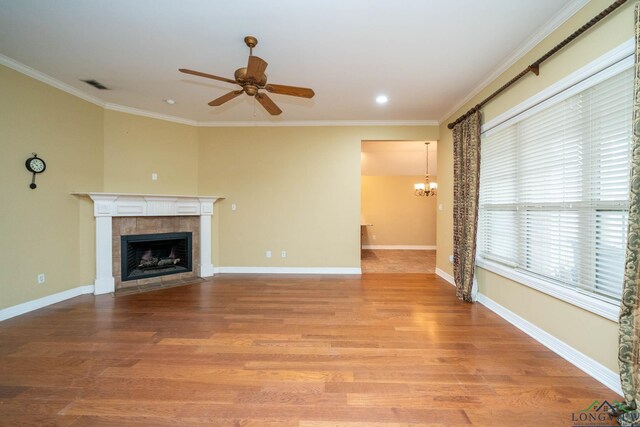 unfurnished living room featuring ornamental molding, light wood finished floors, a tile fireplace, and visible vents