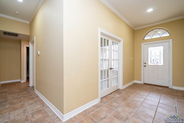 entryway featuring visible vents, crown molding, baseboards, and light tile patterned flooring