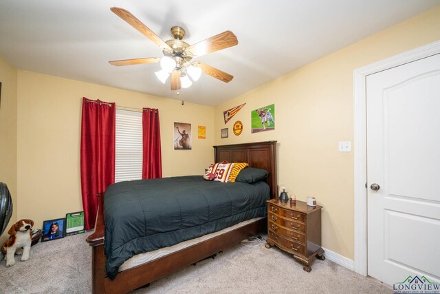 carpeted bedroom featuring ceiling fan and baseboards