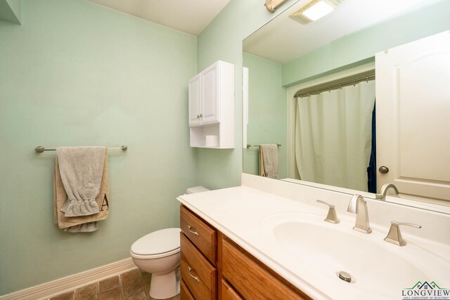 bathroom with visible vents, toilet, vanity, a shower with curtain, and baseboards