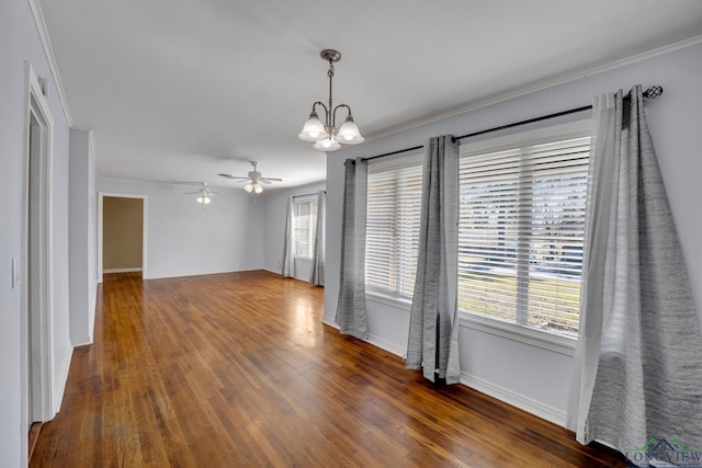 unfurnished room with crown molding, dark hardwood / wood-style flooring, a healthy amount of sunlight, and ceiling fan with notable chandelier