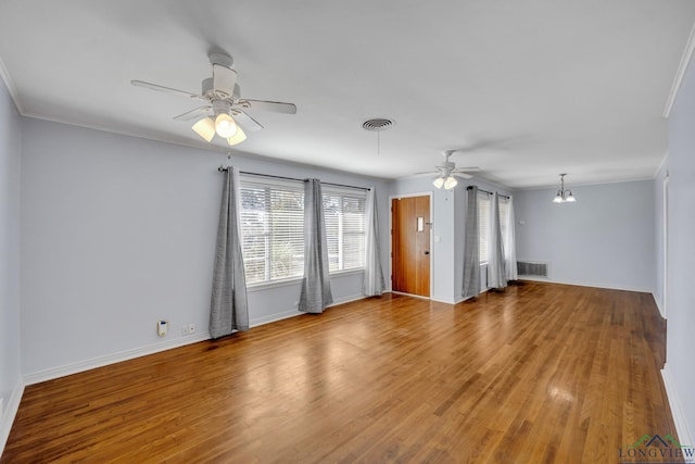 spare room featuring ceiling fan with notable chandelier, wood-type flooring, and ornamental molding