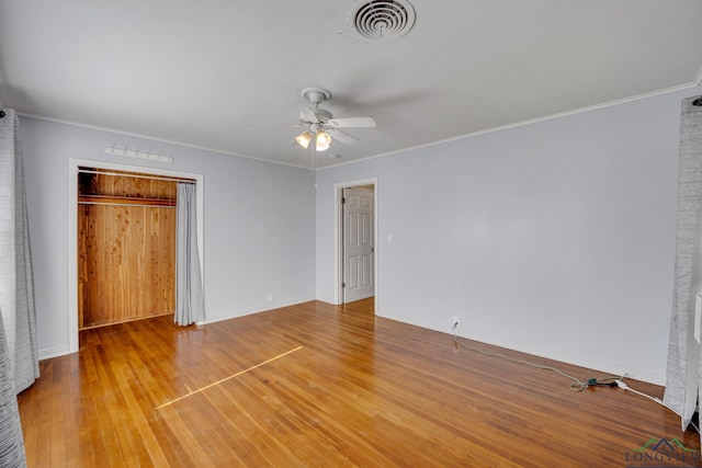 unfurnished bedroom with a closet, ceiling fan, crown molding, and wood-type flooring