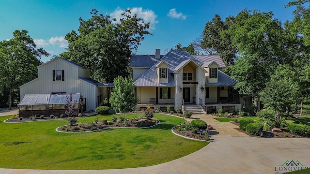 view of front of house with a front yard, an outdoor structure, and covered porch