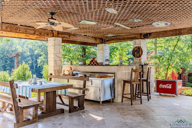 view of patio featuring a bar and ceiling fan