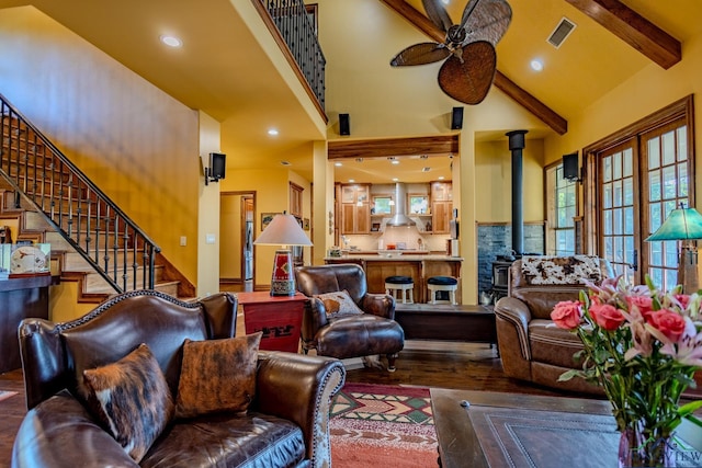 living room with a wood stove, high vaulted ceiling, ceiling fan, beamed ceiling, and wood-type flooring