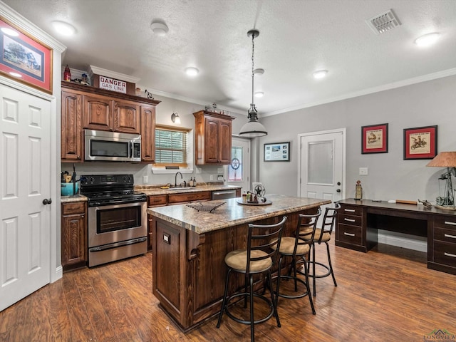 kitchen with a breakfast bar, dark wood-type flooring, crown molding, appliances with stainless steel finishes, and a kitchen island