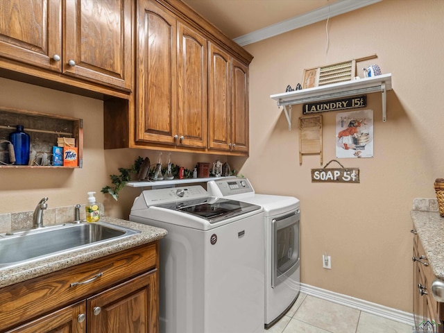 laundry area with cabinets, ornamental molding, sink, light tile patterned floors, and independent washer and dryer