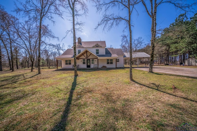 view of front of home featuring a porch, an attached carport, driveway, a chimney, and a front yard