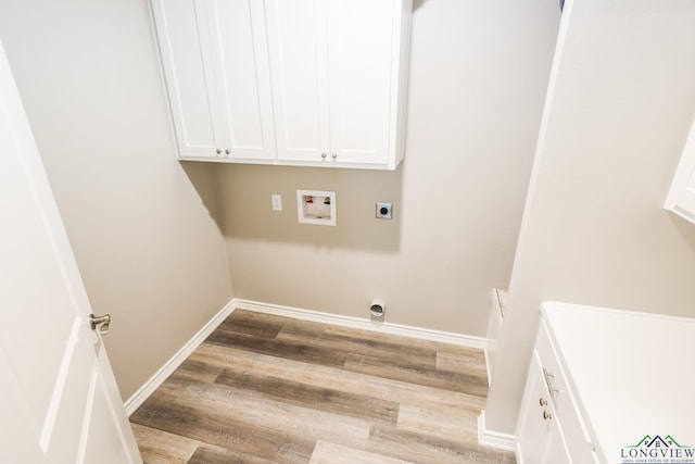 laundry area featuring electric dryer hookup, hookup for a washing machine, hardwood / wood-style floors, and cabinets