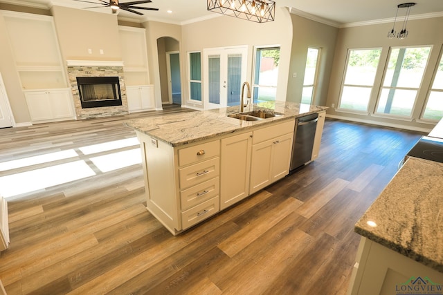 kitchen with a kitchen island with sink, sink, pendant lighting, dishwasher, and white cabinetry