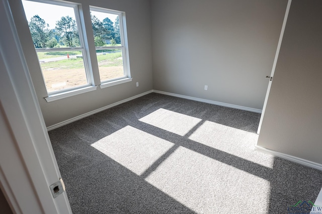 unfurnished room featuring dark colored carpet