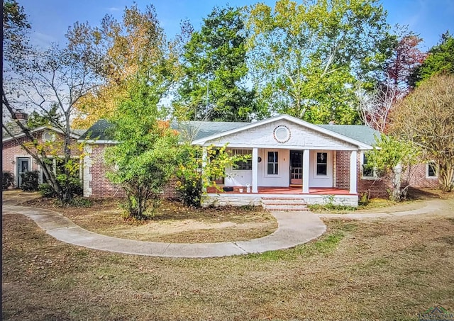 view of front of house featuring covered porch and a front lawn