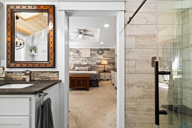 bathroom with vanity, ceiling fan, walk in shower, and wooden walls