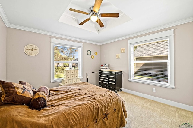 bedroom featuring a tray ceiling, ceiling fan, crown molding, and light colored carpet