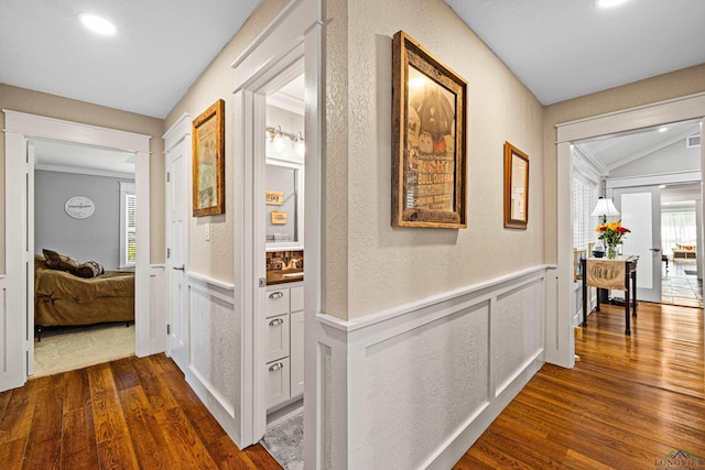 corridor featuring crown molding, dark wood-type flooring, and vaulted ceiling