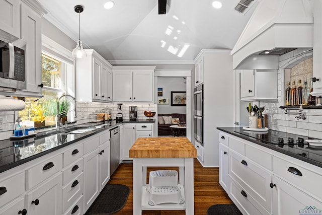 kitchen featuring butcher block countertops, white cabinetry, lofted ceiling, and premium range hood