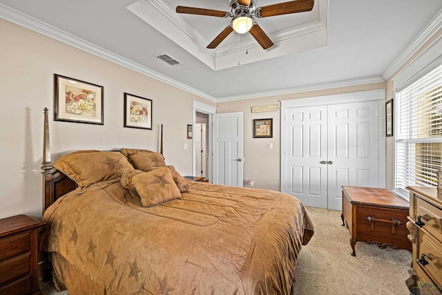 bedroom with a tray ceiling, multiple windows, ceiling fan, and light colored carpet