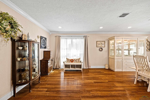 living area with a textured ceiling, crown molding, and dark wood-type flooring