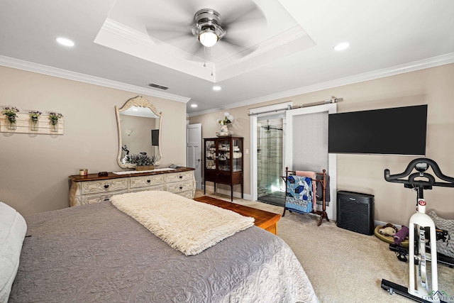 bedroom featuring a barn door, a raised ceiling, ceiling fan, and ornamental molding