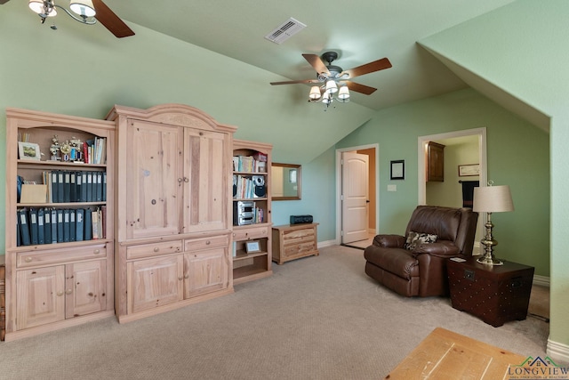 sitting room with light carpet, visible vents, vaulted ceiling, and a ceiling fan