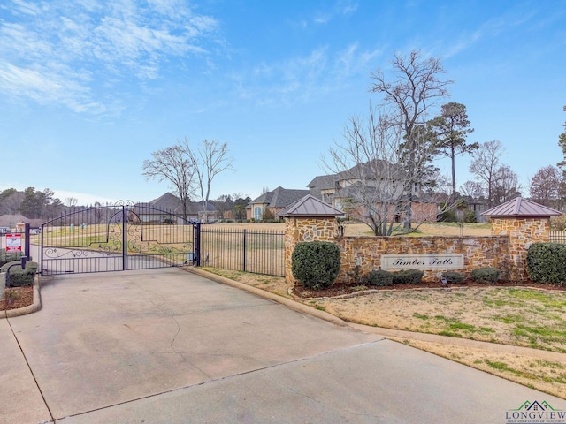 exterior space with a gate, curbs, and a gated entry