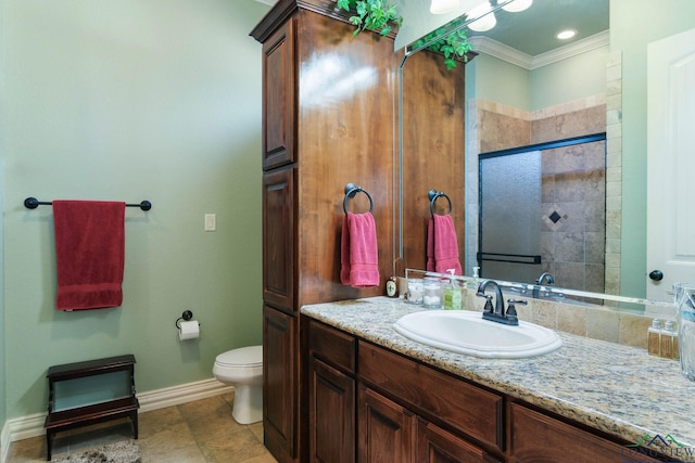 bathroom with baseboards, toilet, a tile shower, crown molding, and vanity