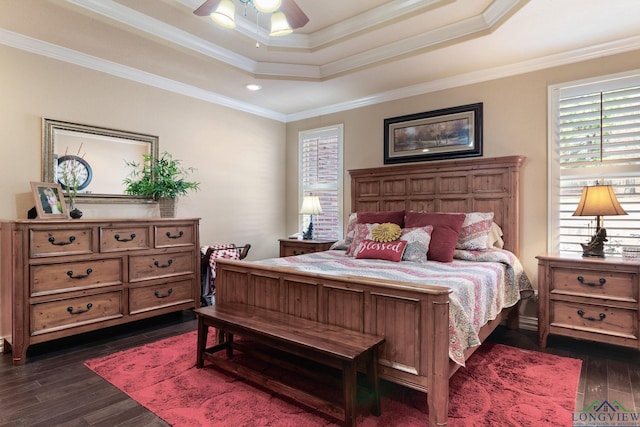 bedroom featuring a tray ceiling, dark wood-type flooring, a ceiling fan, and crown molding