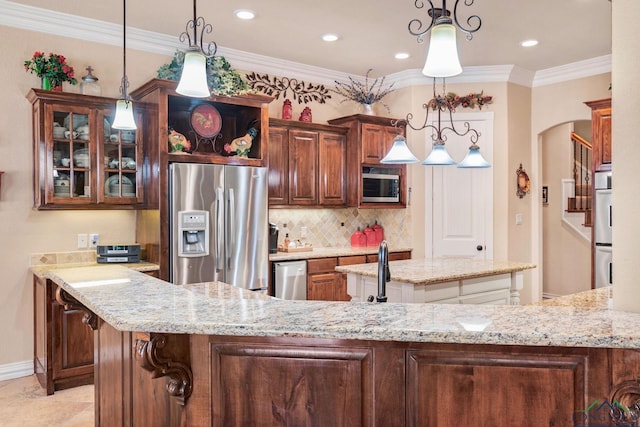 kitchen featuring stainless steel appliances, light stone counters, a kitchen island with sink, and crown molding