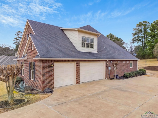 view of side of property with driveway, an attached garage, and brick siding