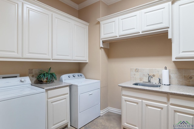 clothes washing area with cabinet space, washing machine and dryer, ornamental molding, and a sink