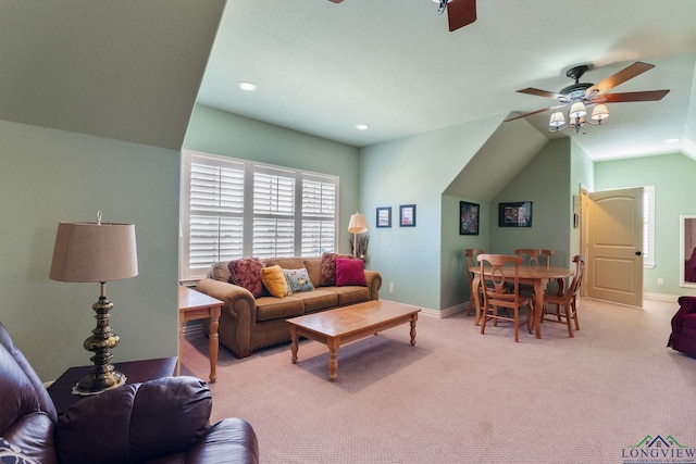 living area featuring lofted ceiling, ceiling fan, baseboards, and carpet flooring