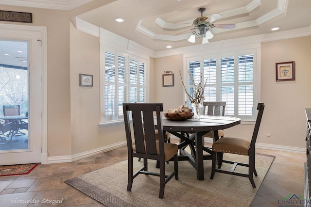 dining area with a tray ceiling and crown molding