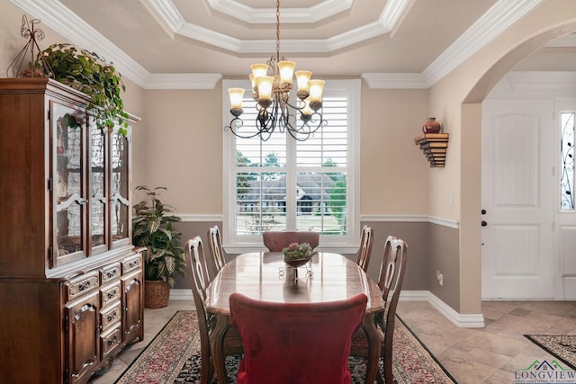 dining space featuring crown molding, arched walkways, a notable chandelier, and a tray ceiling