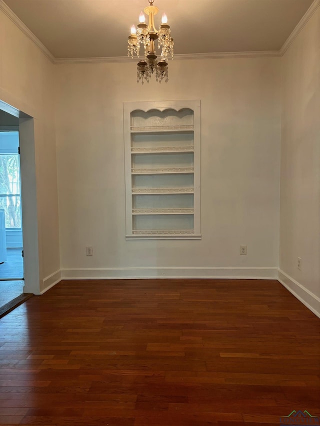 empty room featuring a notable chandelier, dark hardwood / wood-style floors, and crown molding