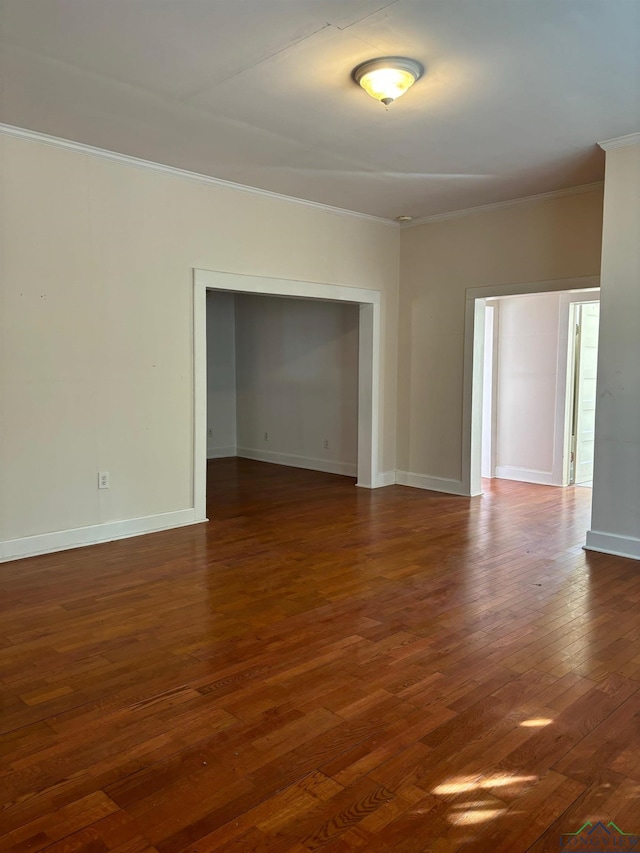 unfurnished room featuring crown molding and dark wood-type flooring