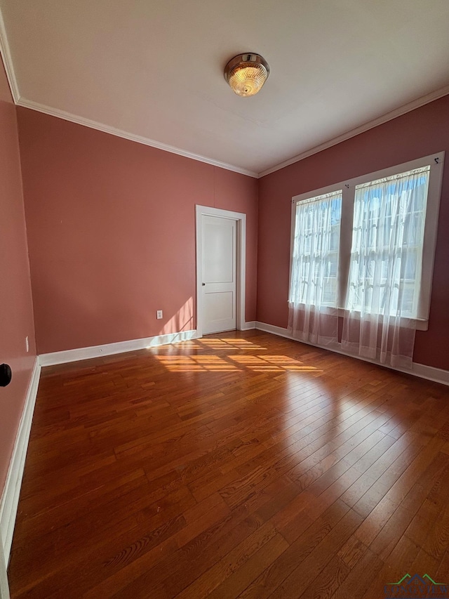 empty room with hardwood / wood-style flooring and ornamental molding